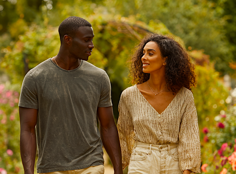 Male and female walking in the park. Image produced using Midjourney